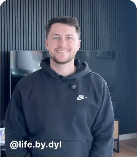 Man in a hoodie smiling in his living room